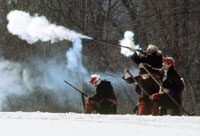 	“Raiders” take aim during the winter 2008 reenactment of the North Meadows skirmish. In the original skirmish of February 29, 1704, English militiamen pursued the Native American and French allies who had just raided Deerfield, Massachusetts, as they retreated with English captives in tow. But the militiamen soon dropped back after assaults by the retreating raiders killed nine colonists.