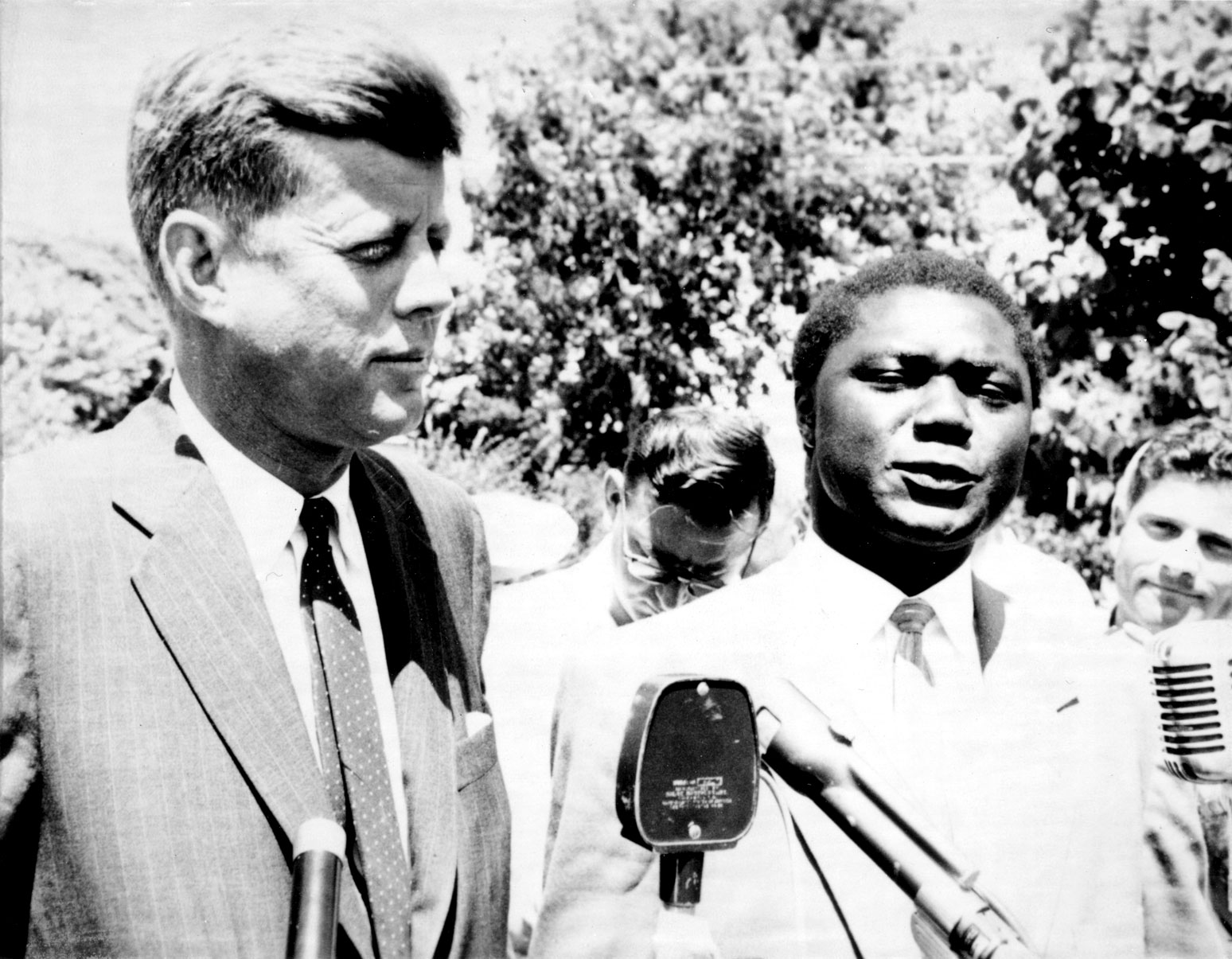 Senator John F. Kennedy and the Kenyan nationalist leader Tom Mboya speak to reporters after their meeting on July 26, 1960, in Hyannis Port, Massachusetts. Mboya had asked Kennedy to intercede with the State Department for funds to transport African students to the United States. Instead, Kennedy Photograph by Boston Herald American