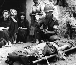 Pfc. Harvey White gives blood plasma to Pvt. Roy Humphrey on August 9, 1943, in Sicily. The plasma came from individual donations made in the United States through the Red Cross Blood Donor Service. Courtesy National Archives and Records Administration, Still Pictures Branch (RG 111, series SC, no. 178198).